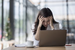 Stressed female designer sitting at desk in modern office